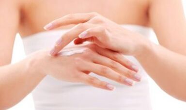 ragazza che applica unguento alla mano